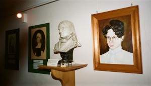 Froebel bust between portraits of his two wives, Charlotte Hoffmeister Froebel on the left and Louise Levin Froebel on the right